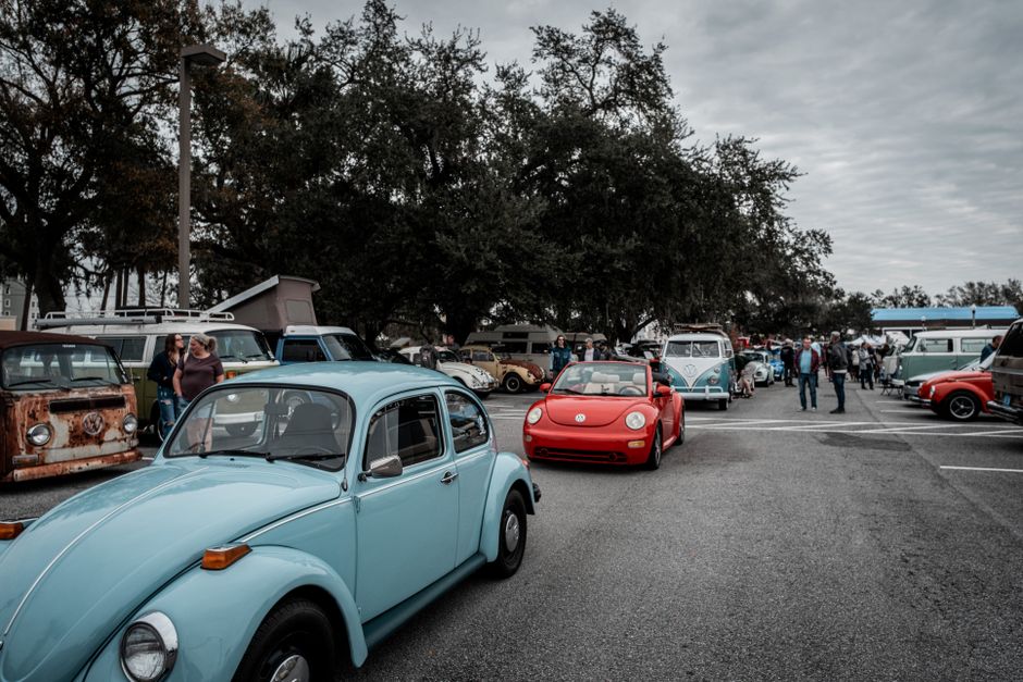 A lively car meet featuring a variety of vintage Volkswagen vehicles in an outdoor setting.